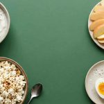 Healthy snacks for weight loss including yogurt, berries, eggs, apple with almond butter and popcorn