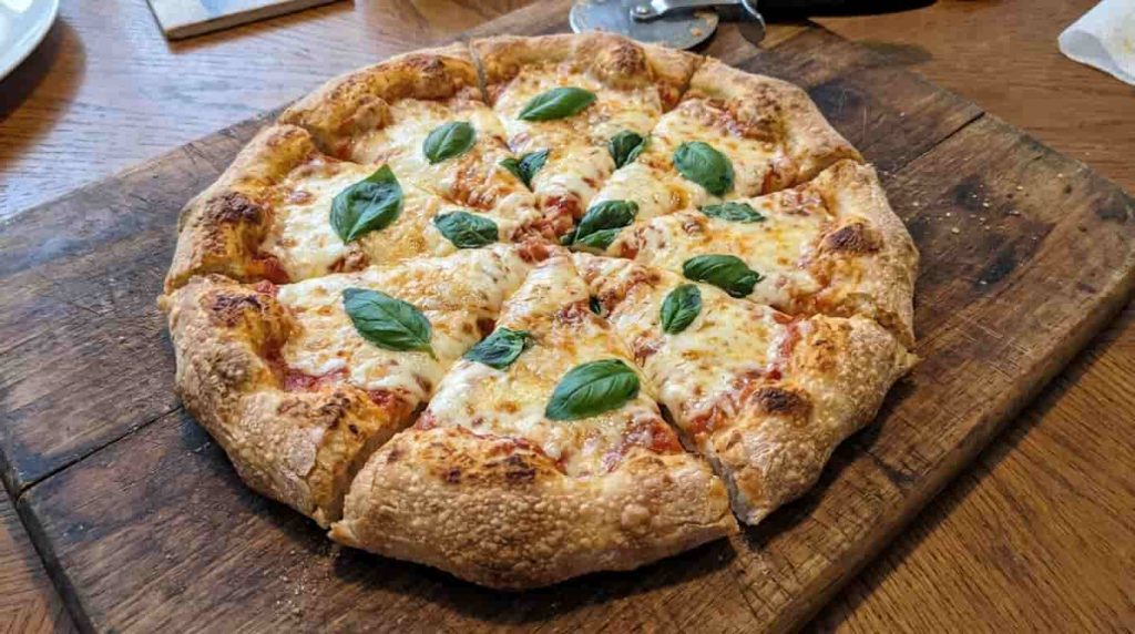 Homemade sourdough discard pizza with cheese and basil