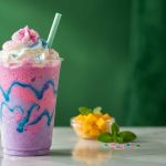 Unicorn Frappuccino with pink and purple swirls, blue drizzle, and whipped cream